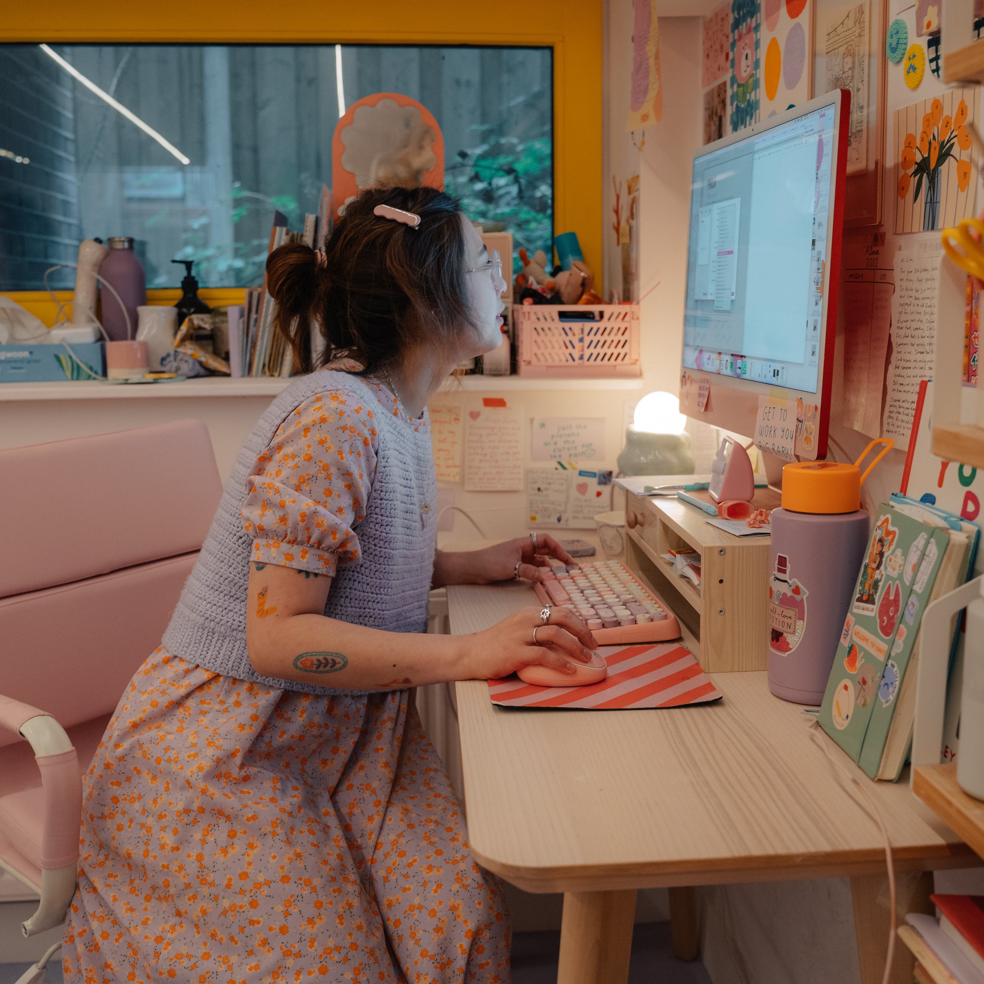 cute girly lina working at a desk with a computer in a colorful room