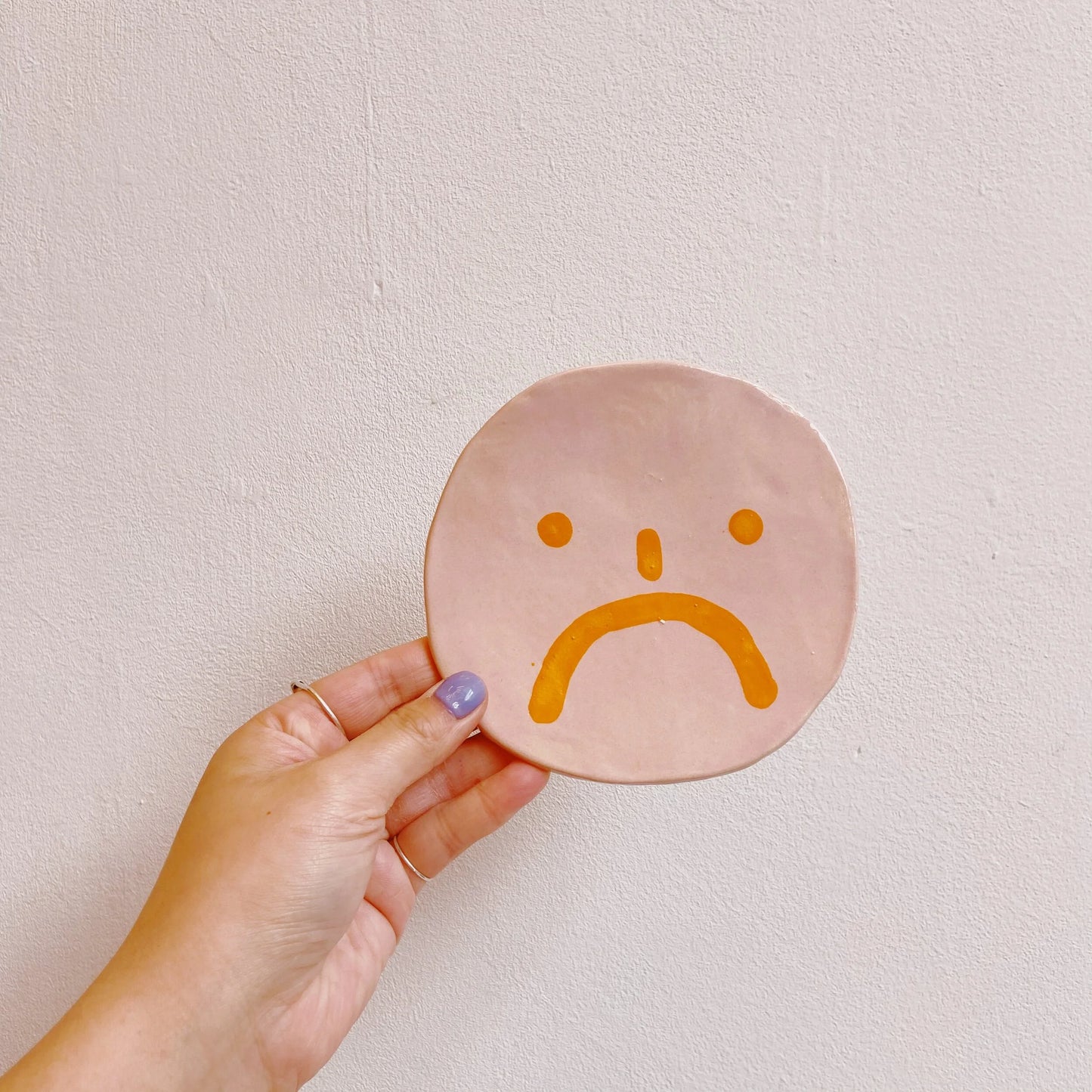 wall hanger | pink with sad face